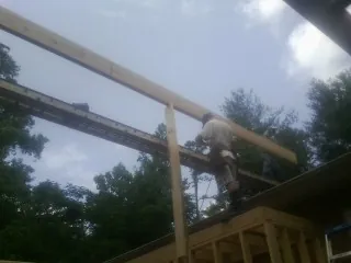 Carpenter setting a ridge beam over a new addition frame — Ice Dam Removal by Roofing Brothers in Parsonsfield