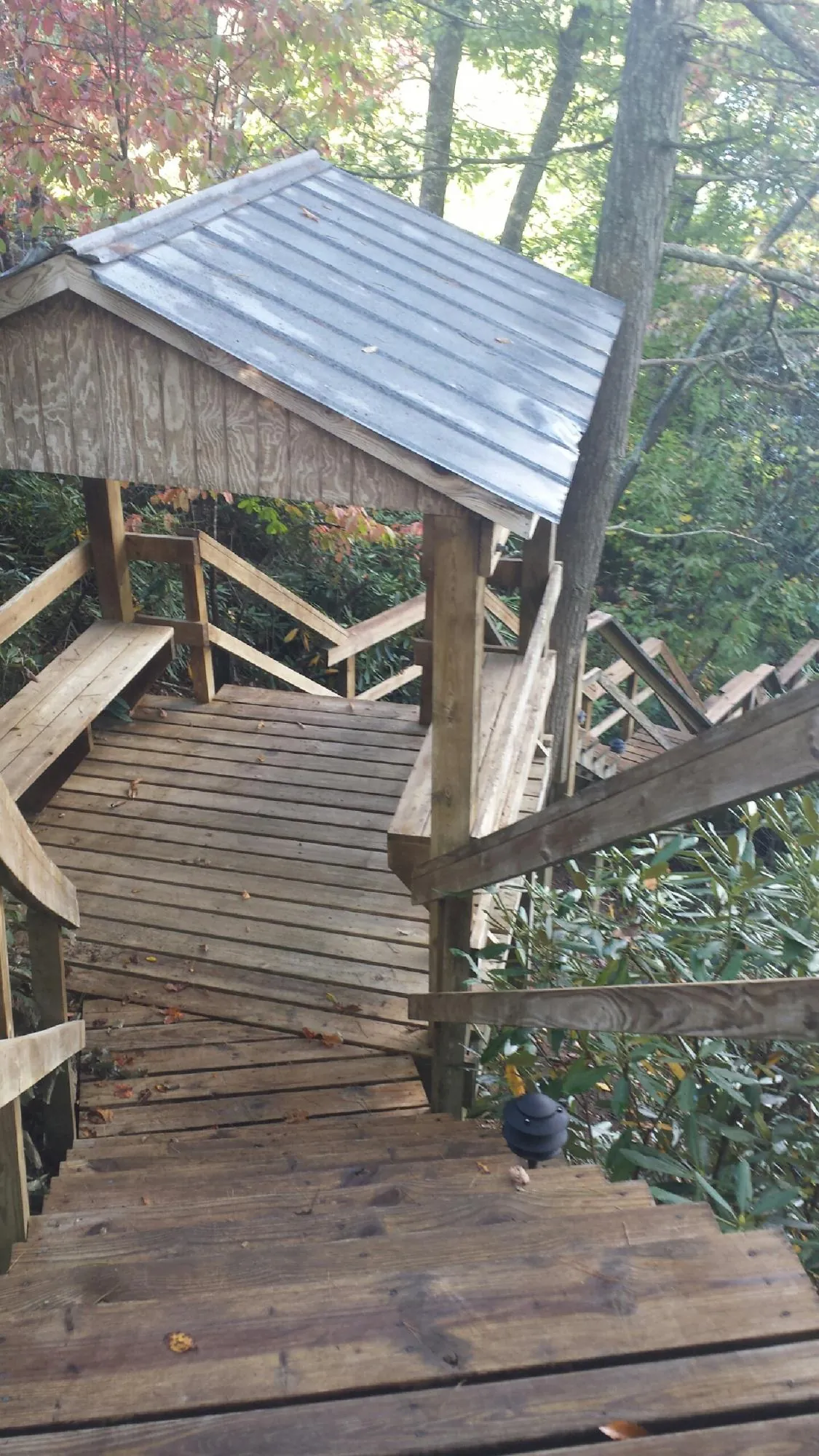 Metal roofed shelter over wooden steps on a wooded walkway — Skylight Repair & Installation work by our crew in Parsonsfield
